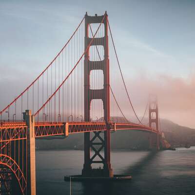 Golden Gate Bridge at sunrise, shrouded in mist over the bay; an iconic backdrop for inspiring teambuilding events designed for HR professionals to foster strong connections and collaboration.